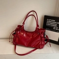 Detail einer roten glänzenden Lackleder-Tote Bag mit Kordelzug und zwei Tragegriffen - Rot