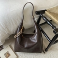 Detailansicht der dunkelbraunen Ledertasche mit Quastenanhänger und Vintage-Textur - Mit Anhänger / Braun