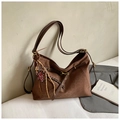 Detail der braunen Vintage-Tasche mit Leopardenmuster, Herz-Bär-Anhänger und Wildledertextur - Kaffee mit Anhänger