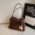 Detail of soft dark brown faux fur tote bag with a cute plush bread charm on marble surface - Coffee With Charms