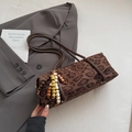 Dettaglio borsa a bauletto leopardata con ciondolo in perle di legno e manici lunghi sottili - Caffè (Con Ciondolo)