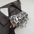 Dettaglio borsa leopardata in ecopelliccia con tracolla in pelle e catena argento - Bianco