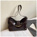 Dettaglio borsa vintage in pelle bordeaux lucida con fibbia metallica dorata elegante - Marrone