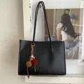 Detailansicht der großen schwarzen Ledershopper mit FANTOR-Logo und Boho-Anhänger - Schwarz