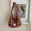 Vue détaillée du sac hobo en toile à carreaux rouges avec breloque ours et patch - Rouge avec pendentif