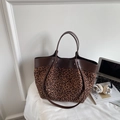 Detailed close-up of leopard print tote bag with leather handles beside a laptop - Small Leopard Print