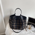 Close-up of checkered tote bag with leather trim alongside a laptop and headphones - Black Grid