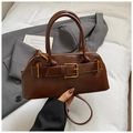 Sac Boston vintage marron foncé avec boucle dorée sur blazer gris et lit blanc - Cuir Huilé Brun