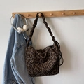 Leopard print hobo tote bag with scrunchie strap hanging on a wooden hook in a room - Green