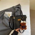 Borsa tote nera lucida con placca dorata e ciondolo a forma di orsetto bruno - Nero con ciondolo