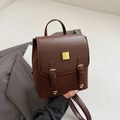 Mochila vintage marrón de cuero en contraste con detalles dorados y diseño elegante - Marrón