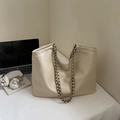 Minimalistische beige Leder-Tote-Bag mit Kettenriemen und künstlerischen Workspace-Requisiten - Cremeweiß