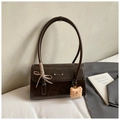 Detalle de bolso retro marrón oscuro con lazo de cuadros y colgante de galleta - Café con Colgante