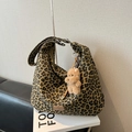Detail der Hobo-Tasche mit Leopardenmuster, Plüschbär-Anhänger und Leder-Logo-Patch - Khaki Mit Anhänger