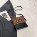 Bolso tote con estampado de leopardo y costuras de cuero negro sobre tela de fondo blanco - Estampado de leopardo