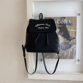 Détail d'un sac à dos en toile noire avec rabat, broderie blanche et bretelles réglables - Noir