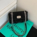Chique zwarte crossbodytas met textuur en strass-sluiting op een groen boek - Zwart zonder Hanger