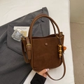 Detailed close-up of a brown suede bucket bag featuring high-quality leather and wooden bead - Brown (With Pendant)