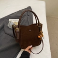 Macro detail of dark brown faux suede texture and decorative wooden beads on bucket bag - Coffee (With Charm)