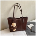 Detailaufnahme dunkelbraune Flecht-Shopper-Tasche mit flauschigem Bären-Anhänger - Kaffee Mit Bärenanhänger Stil