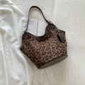 Borsa hobo con stampa leopardata e finiture in pelle marrone su una camicia bianca - Marrone