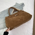 Dettaglio della borsa tote in pelle scamosciata marrone con fibbia e borchie argentate - Marrone