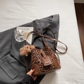 Detalle del bolso de leopardo con ribete de cuero marrón y un tierno amuleto de osito - Marrón con Colgante