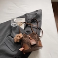 Detalle de bolso saco de leopardo con toques de cuero marrón y un tierno oso de peluche - Café Con Amuletos