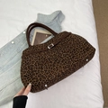 Dettaglio della borsa leopardata con fibbia marrone e borchie metalliche sul fondo - Stampa leopardata