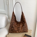 Primer plano del bolso hobo de leopardo con correa de cuero marrón en mesa de madera - Marrón
