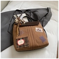 Détail d'un sac à dos marron vintage avec écussons brodés et breloques ourson mignon - Avec Pendentif / Marron