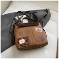 Détail d'un sac à dos en toile vintage avec patchs brodés rétro et garnitures en cuir - Sans Pendentif / Marron