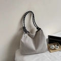 Close-up of beige corduroy tote bag with braided black and white rope handles - Off White
