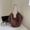 Nahaufnahme der braunen Veloursleder-Tragetasche mit Lederriemen und dekorativer Tasche - Braun