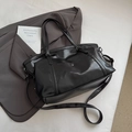 Close-up of black PU leather tote bag with silver hardware and adjustable shoulder strap - Black