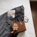 Detalle del bolso tipo cubo de ante marrón con costuras de rombos y colgante de oso - Marrón con Colgante