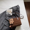 Detalle de bolso cubo retro marrón con textura acolchada y colgante de oso de peluche - Café Con Amuletos