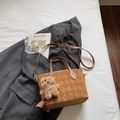 Detalle de bolso saco marrón vintage con textura acolchada, logo y colgante de oso - Marrón Amarillento Con Colgante