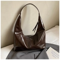 Detail der glänzenden dunkelbraunen Hobo-Tasche aus Kunstleder mit eleganter Vertikalnaht - Braun