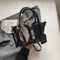 Detail of black textured bucket bag with silver lock and checkered silk scarf handle - Black