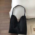 Detalle del bolso tote de ante negro con corte en V minimalista y correas delgadas - Negro