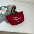 Detail view of red suede tote bag with Life is So Good embroidery and plaid lining - Red