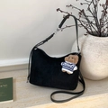 Detail of black suede dumpling bag featuring a cute brown bear charm and silver hardware - Black with Pendant