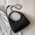 Detailansicht einer schwarzen Halbmondtasche aus Wildleder mit verstellbarem Riemen auf Stoff - Groß / Schwarz
