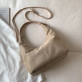 Detailansicht der beigen Wildleder-Halbmondtasche mit verstellbarem Gurt auf weißem Stoff - Groß / Khaki