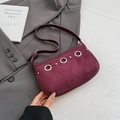 Bolso de hombro granate de ante con anillas plateadas y tachuelas sobre un traje - Rojo