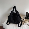 Detalle de mochila negra YOJI BEAR con cordón en un escritorio con portátil y auriculares - Negro
