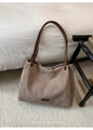 Detailed macro of coffee brown suede tote bag with rectangle leather logo on soft rug - With Pendant / Khaki