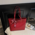 Detail van rode shopper met ruitpatroonreliëf en een decoratief zijden lint erop - Wijnrood Gewatteerd