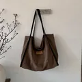 Detailansicht der dunkelbraunen Wildleder-Tragetasche mit HOPEFUL-Lederetikett und Vintage-Struktur - Braun